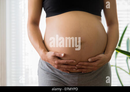 Baby bump, image de 8 mois pregnant woman holding her bump Banque D'Images