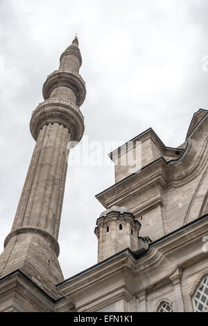 ISTANBUL, Turquie — L'un des minarets jumeaux de la mosquée Nuruosmaniye s'élève contre le ciel, mettant en valeur le style architectural baroque ottoman. La mosquée, achevée en 1755 sous le règne du sultan Osman III, représente la première mise en œuvre majeure d'éléments baroques dans l'architecture religieuse ottomane. Ces minarets distinctifs intègrent des éléments de conception baroque traditionnels islamiques et européens. Banque D'Images