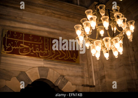 ISTANBUL, Turquie / Türkiye - Un anneau de lumières à l'intérieur de la mosquée Nuruosmaniye, richement décoré dans un style ottomon-baroque. La mosquée Nuruosmaniye, située à côté du Grand Bazar d'Istanbul, a été achevée en 1755 et a été la première et la plus grande mosquée à être construite dans le style baroque ottoman. Banque D'Images