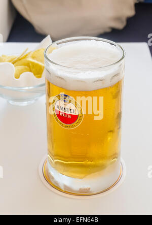 Amstel beer mug et chips snack sur une table Banque D'Images