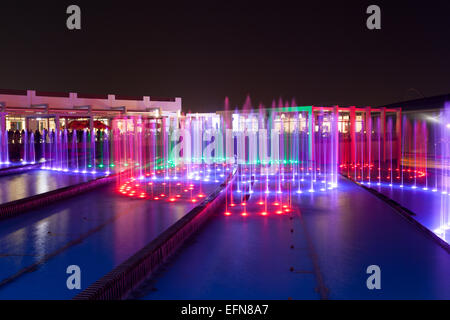 Fontaine au parc à thème Ferrari World est éclairée la nuit. Banque D'Images