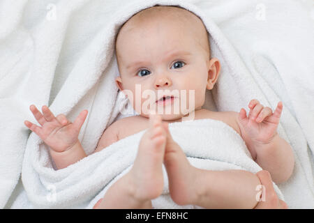 Mignon bébé couché sur une serviette blanche Banque D'Images