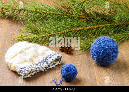 Balle de threads, le tricot, les cônes de pin et de la direction générale sur fond de bois de pin Banque D'Images