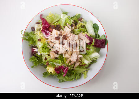 Salade de poulet aux tomates et au raisin blanc dans un bol. Plus isolé sur fond blanc Banque D'Images