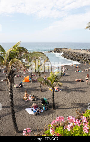 Les touristes à prendre le soleil sur la plage de Playa Jardin, Puerto de la Cruz, Tenerife Banque D'Images