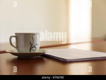 Tasse et une pile de papiers sur son bureau Banque D'Images