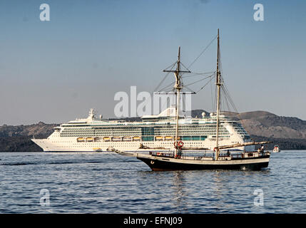 Santorin, Grèce. 29 Sep, 2004. Une goélette à deux-mâts voiles passé le bateau de croisière Royal Caribbean International Brilliance of the Seas dans le lagon de la caldeira (cratère volcanique) au-delà de l'ancien port de Gialos ci-dessous de Fira, capitale de Santorin. Le point le plus au sud des Cyclades, membre du groupe de l'île de Santorin, colorée est le site touristique et destination de croisière. © Arnold Drapkin/ZUMA/Alamy Fil Live News Banque D'Images