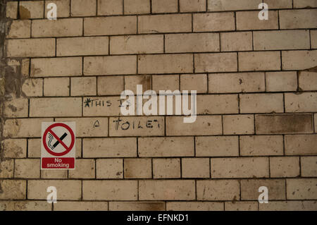 Mur carrelé avec aucun signe de fumer et de lettrage à la main ce n'est pas une toilette Banque D'Images