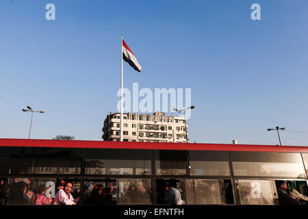 Le Caire, Égypte. Feb 8, 2015. Un bus égyptien rider donne un V-sign comme il passe par le symbolique place Tahrir où un drapeau national géant de l'Égypte est observé au sommet d'un mât nouvellement installés, la dernière tentative de rechercher l'unité autour du pays au Caire, capitale de l'Égypte, le 8 février 2015. Credit : Cui Xinyu/Xinhua/Alamy Live News Banque D'Images