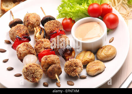 Boulettes de viande hachée brochettes cuites comme trempette avec des champignons et on white plate Banque D'Images
