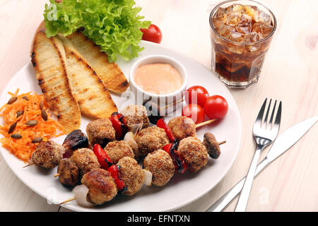 Boulettes de viande hachée cuite au four comme brochettes avec salade de carottes on white plate Banque D'Images