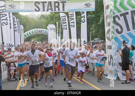 Color Run Runners portant des t-shirts colorés et bandeaux avec enthousiasme en rafale à partir de la ligne de départ à Asheville, NC Banque D'Images