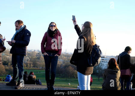 Une femme à prendre des photos avec un téléphone intelligent à Primrose Hill, Londres Banque D'Images