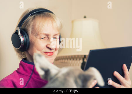 Femme âgée caucasienne souriante vêtue d'un casque tenant une tablette Banque D'Images