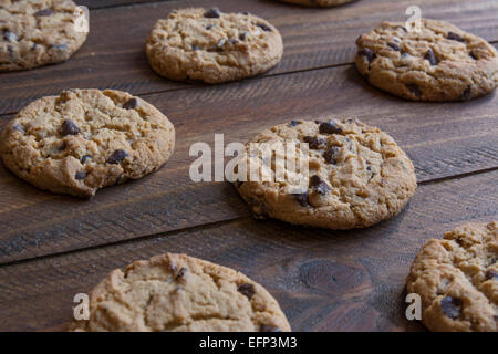 Des cookies aux pépites de chocolat sur la table en bois pour se rafraîchir, avec soft focus à l'arrière-plan Banque D'Images