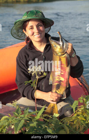 Femme avec des poissons saumon dans ses mains, péninsule du Kamchatka, Russie Banque D'Images