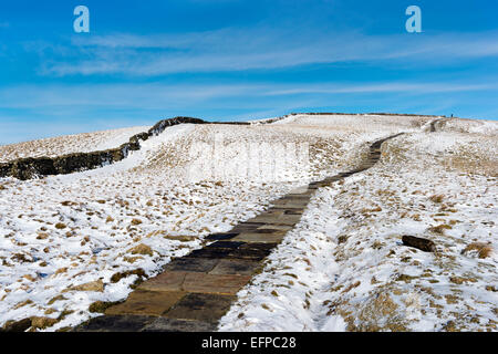 Le Pennine Way Sentier national en montant vers le haut de la neige couverts Pen-y-ghent hill, Horton dans Ribblesdale, Yorkshire Dales National Park, Royaume-Uni Banque D'Images