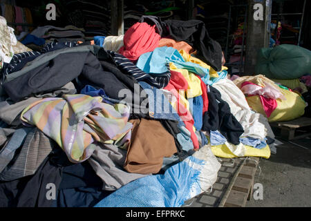 Les vêtements et les restes de tissu sont empilées sur une rue de ville de Phnom Penh, Cambodge. Banque D'Images