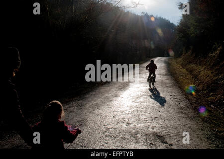 Les enfants à vélo dans Cardinham woods très populaire auprès des marcheurs, cyclistes et promeneurs de chiens près de Bodmin, North Cornwall. Banque D'Images