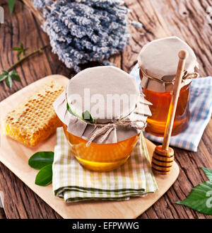 Les canettes en verre pleine de miel sur vieille table en bois. Banque D'Images
