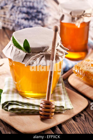 Les canettes en verre pleine de miel sur vieille table en bois. Banque D'Images