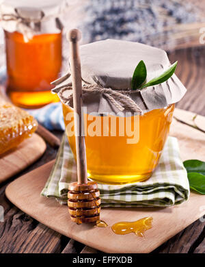 Les canettes en verre pleine de miel sur vieille table en bois. Banque D'Images