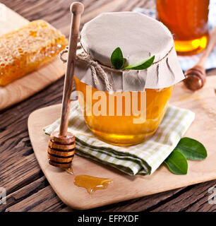 Les canettes en verre pleine de miel sur vieille table en bois. Banque D'Images