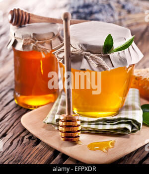 Les canettes en verre pleine de miel sur vieille table en bois. Banque D'Images