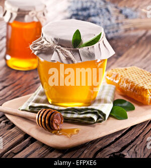 Les canettes en verre pleine de miel sur vieille table en bois. Banque D'Images