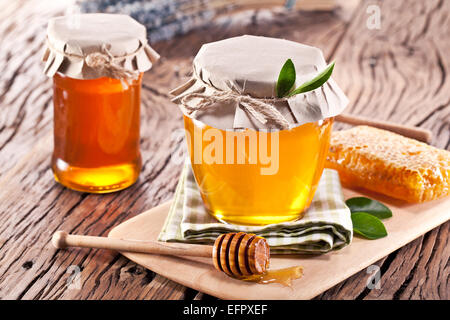 Les canettes en verre pleine de miel sur vieille table en bois. Banque D'Images