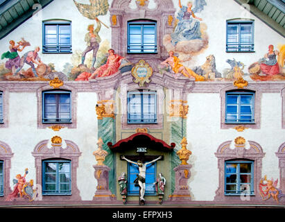 Weilheim, Bavière, Allemagne. Façade peinte de chambre le Poltnerstrasse. Statue du Christ sur la croix Banque D'Images