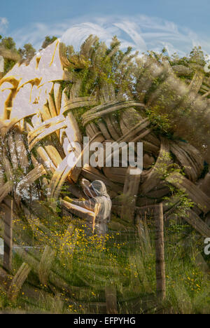 Double exposition d'apiculteur dans un champ de fleurs sauvages paître ses ruches avec image de paille traditionnel skep Banque D'Images