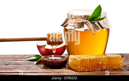 Le verre peut pleine de miel, de pommes et d'abeilles sur le bois. Chemins de détourage. Banque D'Images