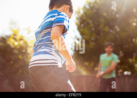 Père et fils à jouer au football dans le jardin Banque D'Images