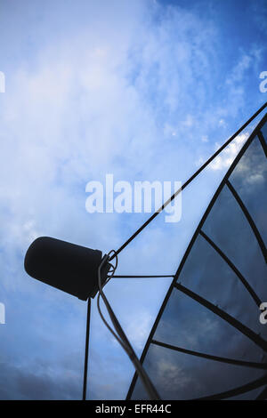 Noir Double antenne satellite contre le bleu ciel nuageux tôt le matin Banque D'Images