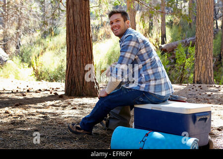 Jeune homme dans la forêt assis sur la boîte, Los Angeles, Californie, USA Banque D'Images