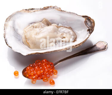 Huîtres fraîches ouvert et cuillère en argent plein de caviar. Isolé sur un fond blanc. Banque D'Images