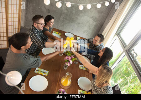 Groupe d'amis autour de la table, verres, faire du pain grillé Banque D'Images