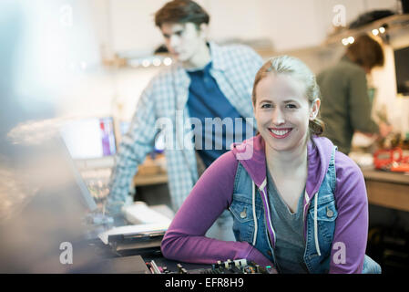Une jeune femme et l'homme, l'ordinateur personnel dans un atelier de réparation. Banque D'Images