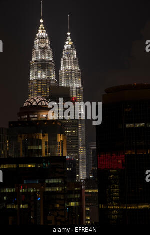 Les tours jumelles de Petronas tower vu depuis le toit d'un bâtiment voisin de nuit à Kuala Lumpur, Malaisie. Banque D'Images