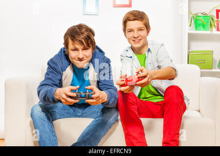 Happy friends détiennent les leviers de commande et console de jeux play Banque D'Images