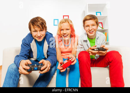 Les adolescents heureux tenir les leviers de commande et console de jeux play Banque D'Images