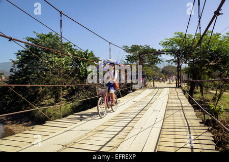 Les enfants de l'école de traverser un pont, Vang Vieng, Laos. Banque D'Images