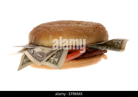 Un fast-food hamburger avec de l'argent en elle. Peut illustrer des concepts tels que le salaire minimum pour les travailleurs de la restauration rapide / QSR. Banque D'Images