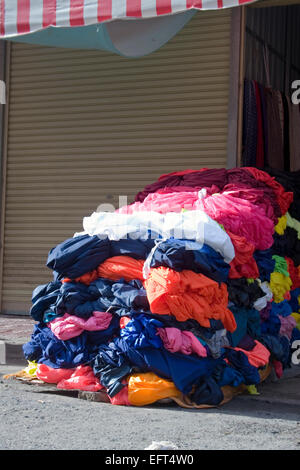 Les vêtements et les restes de tissu sont empilées sur une rue de ville de Phnom Penh, Cambodge. Banque D'Images