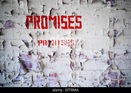 'Promesses, promesses' écrit en peinture sur un mur se détache. Banque D'Images