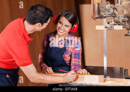 Carpenter à la collègue au marquage sur plank Banque D'Images