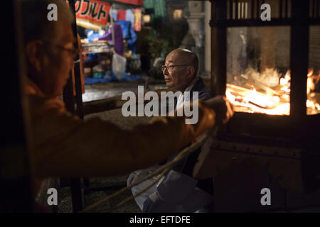 Célébrations de la veille du Nouvel An au temple Yasaka. Le rituel traditionnel consiste à brûler du bois de lattes minces sur lesquelles les gens ont écrit leurs souhaits. Les amateurs de briller la lumière également une corde de paille de l'incendie qu'ils tournent et prendre avec eux à la maison. Banque D'Images