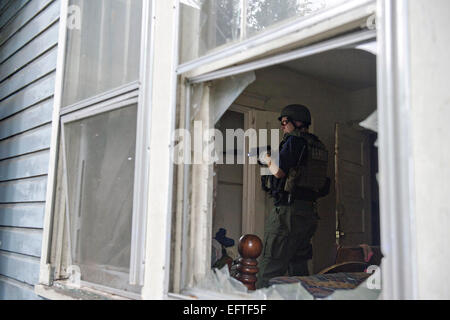 US Marshals Service agent une arme au avec garantit une chambre après un raid sur les gangs de la drogue au cours de l'opération Triple Beam 28 octobre 2014 dans Mobile, Alabama. L'opération a donné lieu à 163 jeunes arrêtés. Banque D'Images