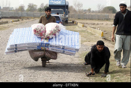 Karachi, Pakistan. 10 Février, 2015. Personnes déplacées à l'Agence de Khyber Bara civils portent secours reçus de la Société du Croissant-Rouge du Pakistan Khyber Pakhtunkhwa à Al-Khidmat point de distribution de la direction du camp de personnes déplacées à Peshawar le mardi 10 février 2015. Credit : Asianet-Pakistan/Alamy Live News Banque D'Images